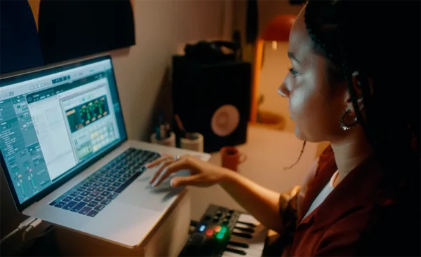 Mujer joven usando Reason 12 en su computadora portátil